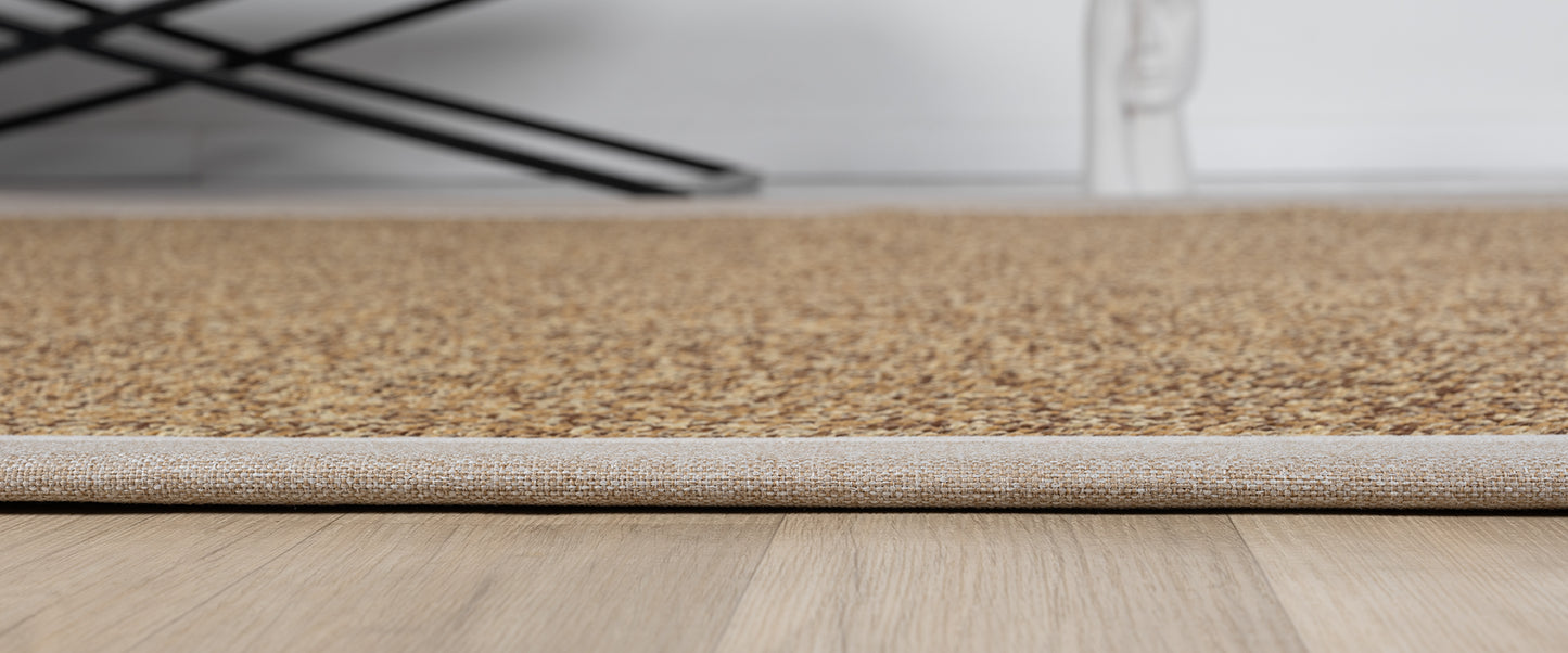 Sisal halının altı, detaylı dokusu ve kenar kısmı, modern bir zeminle uyumlu.