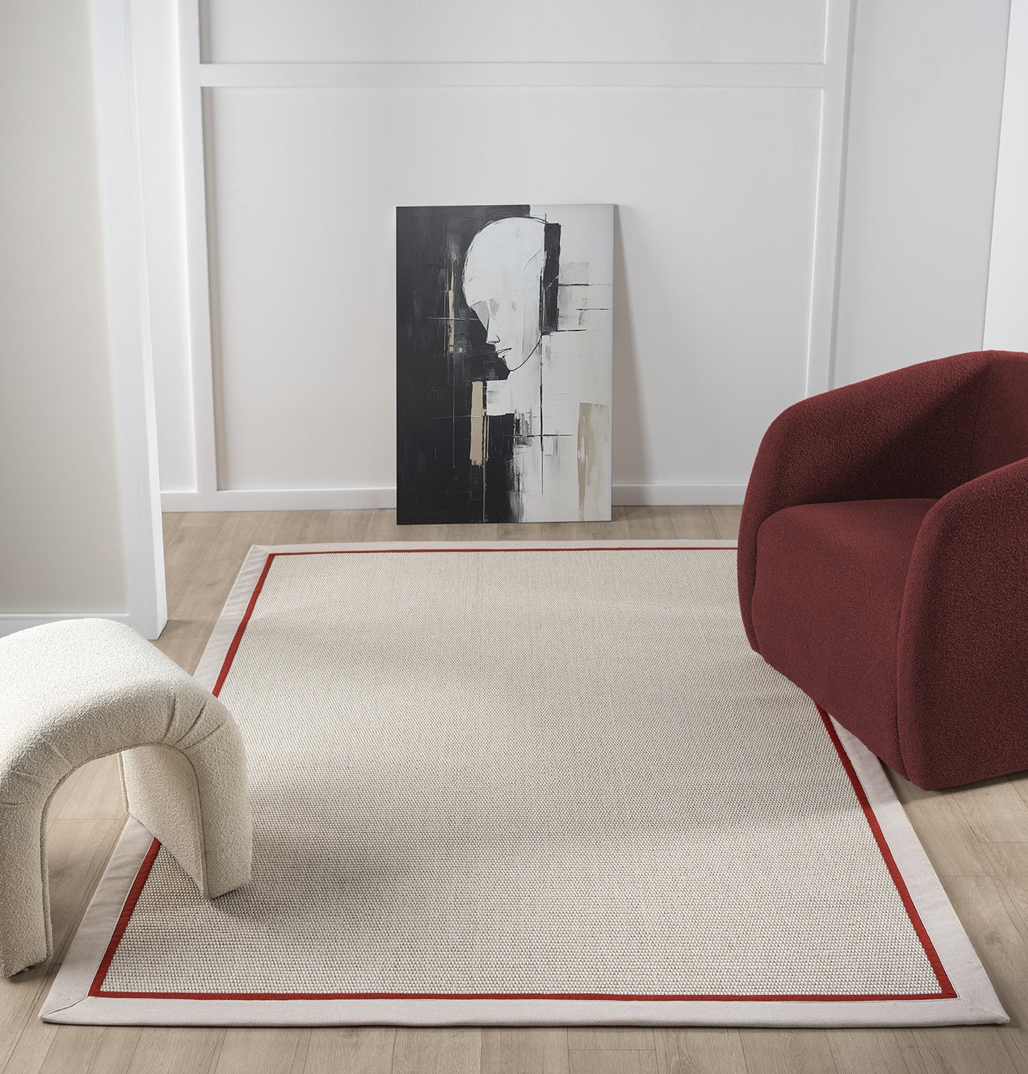 Modern bir yaşam alanında, kırmızı bordürü olan sisal halının geniş görünümü ve çağdaş dekor ile uyumu.