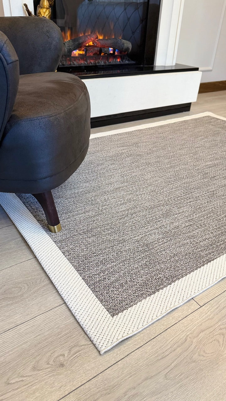 Yüksek bir bakış açısıyla gösterilen sisal halı ve koltuğun detayları, geniş bir oturma alanı.