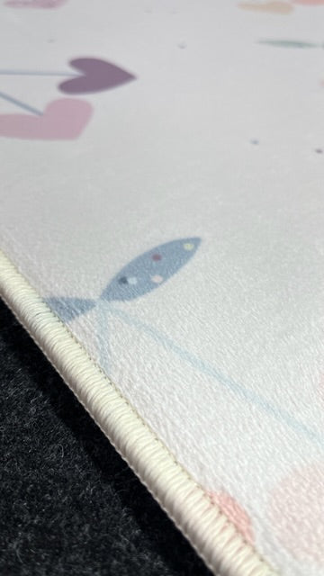 Pastel desenli halının detaylı görünümü, dokusu ve kenar dikişleri vurgulanıyor.