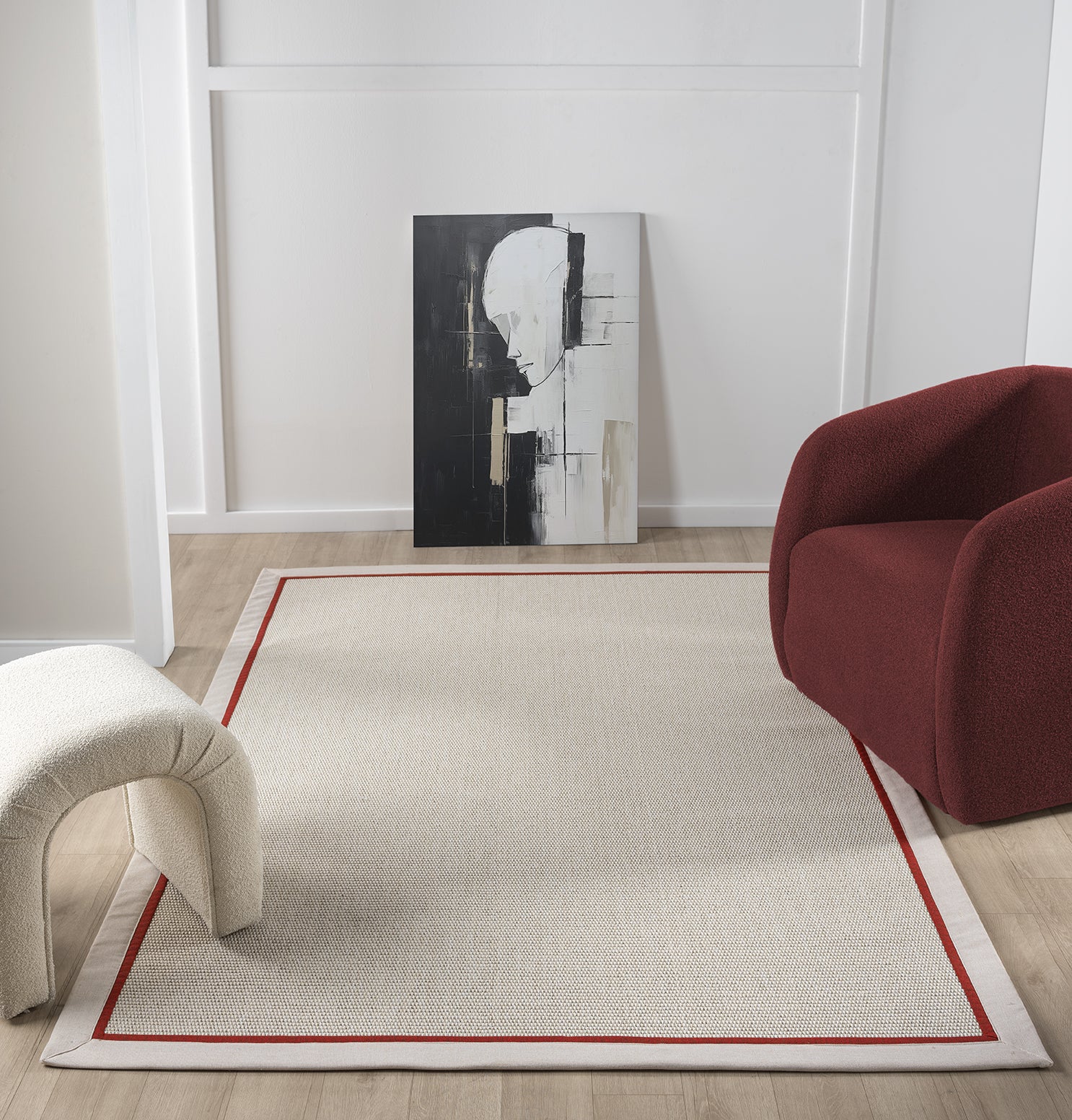 Modern bir yaşam alanında, kırmızı bordürü olan sisal halının geniş görünümü ve çağdaş dekor ile uyumu.