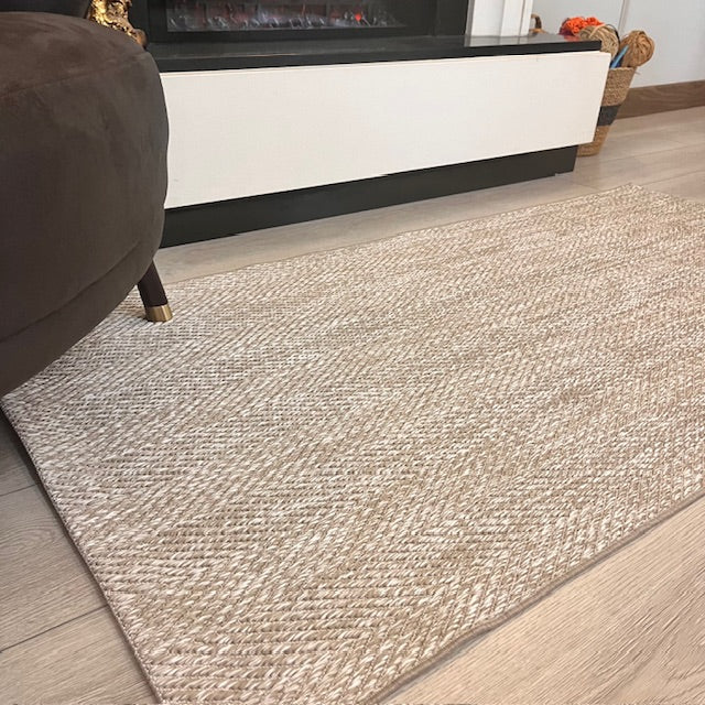 Elit yumuşak dokulu sisal halı, şık bir oturma alanında serili. Halının rengi açık, doğal tonlarda.