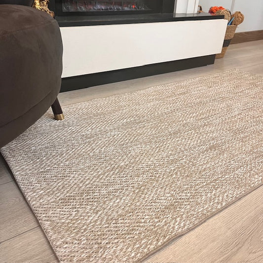 Elit yumuşak dokulu sisal halı, şık bir oturma alanında serili. Halının rengi açık, doğal tonlarda.